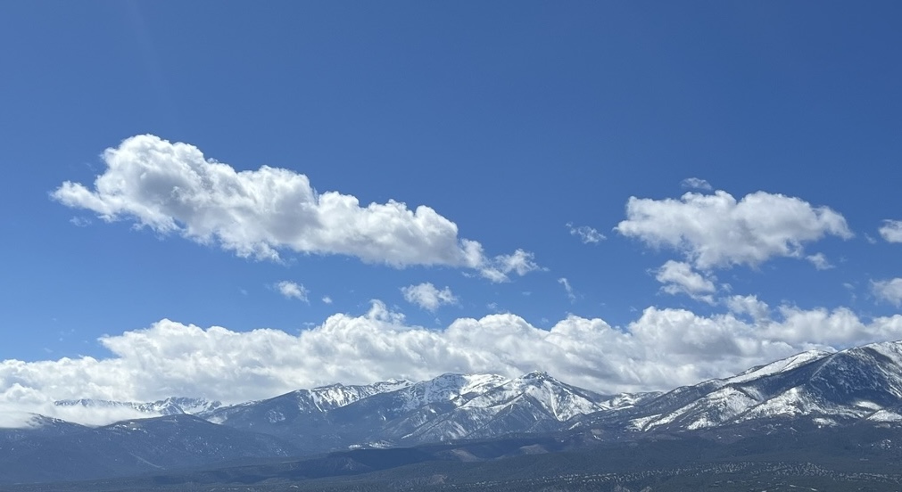 Snow-capped Rocky Mountain peaks under a wide sky along Colorado's Front Range