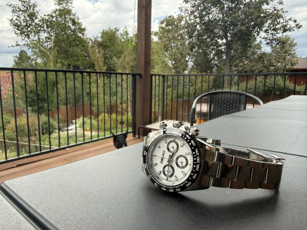 Panda Chronograph Homage — resting on an outdoor table with a deck and trees behind it